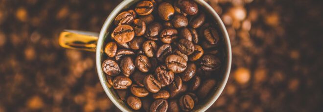 A coffee cup full of coffee beans.
