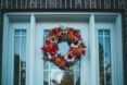 A fall leaf wreath hanged on a white doorway