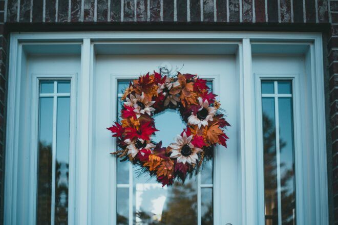 A fall leaf wreath hanged on a white doorway