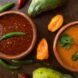 Two bowls of red and orange salsa.