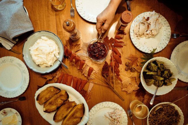 Thanksgiving table spread with food, candles and decor