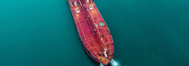 A red oil tanker on the water.