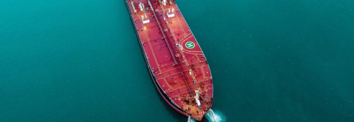 A red oil tanker on the water.
