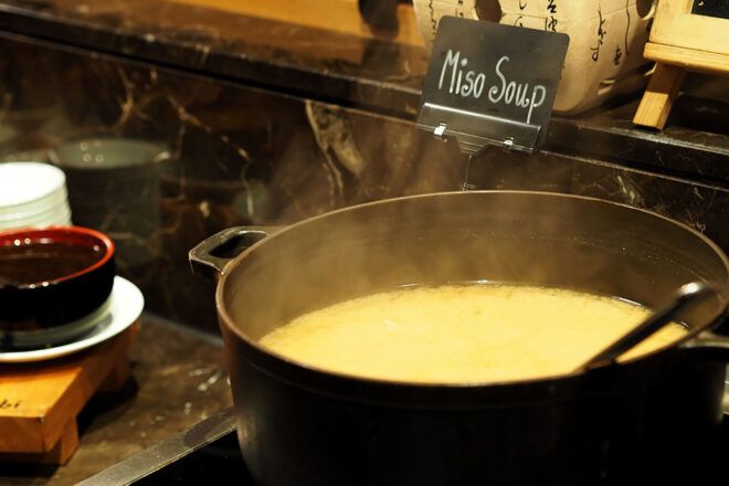 A pot of soup next to a sign that says "Miso Soup."
