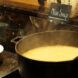 A pot of soup next to a sign that says 
