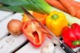 A knife chopping into a pile of vegetables.