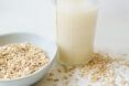 A bowl of oats next to a glass of milk.