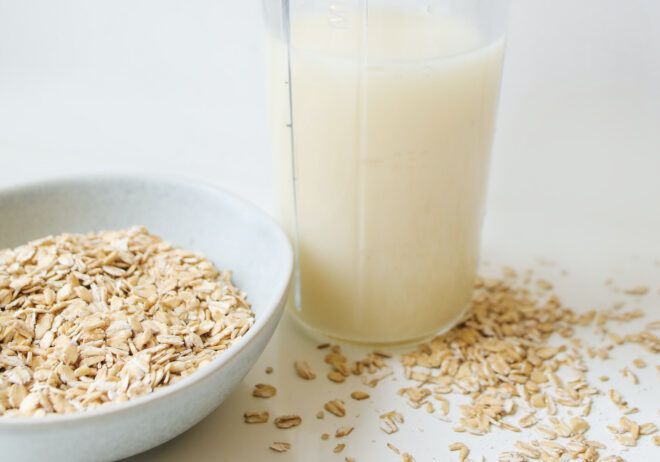 A bowl of oats next to a glass of milk.
