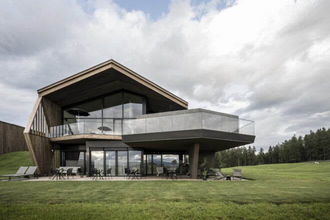 A building with a patio area sit in a grassy landscape