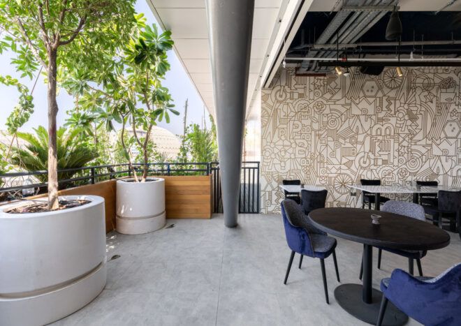 View of restaurant to the right adjacent to the greenery on balcony to the left