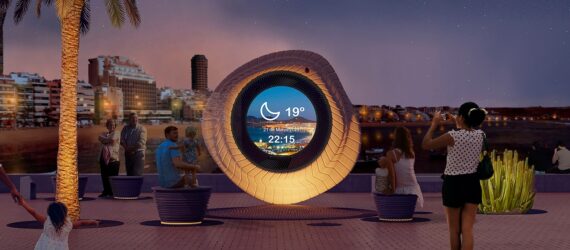 A large circle ring that it has a see through middle sits by the ocean during the evening time