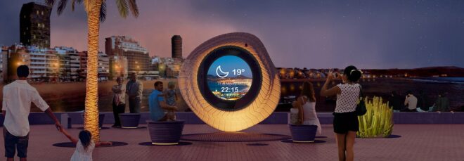 A large circle ring that it has a see through middle sits by the ocean during the evening time