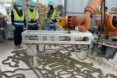 People on a construction site working with robotic equipment.