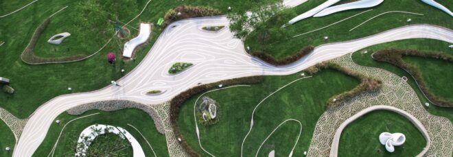 An aerial view of a concrete park surrounded by lush greenery.