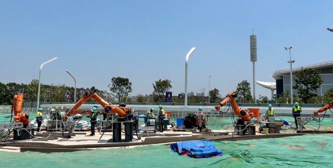 People on a construction site working with robotic equipment.