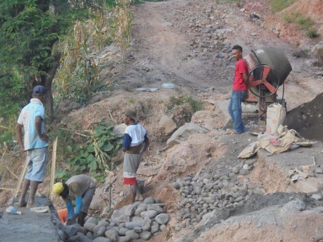 Four men building a wall for floods