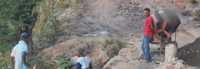 Four men building a wall for floods