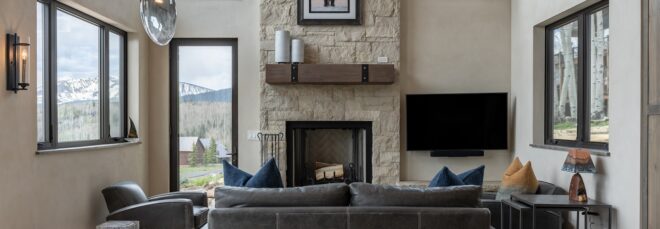 Living room with a sofa facing a fireplace and painting above a shelf