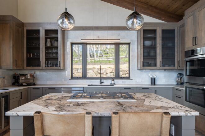 A kitchen island with two lamps hung above it