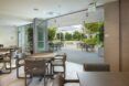 A room with chairs and tables opening up to the outside dining area