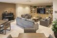 Living room area with sofas, tables, a piano and TV