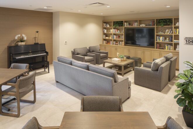 Living room area with sofas, tables, a piano and TV