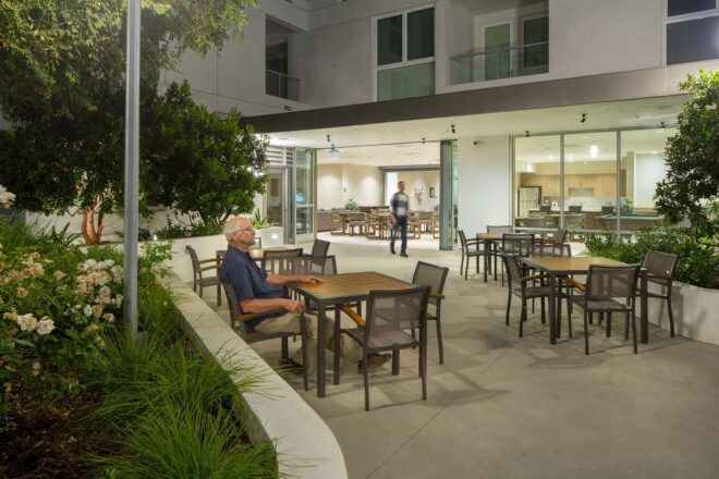 Outside resting area where a man is sitting at a table during what looks like the night time