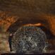 A man standing by a dome art structure in a cave