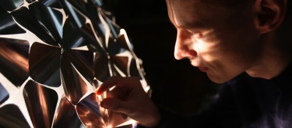 A person peering through the dome, the light from inside the dome shining on their face