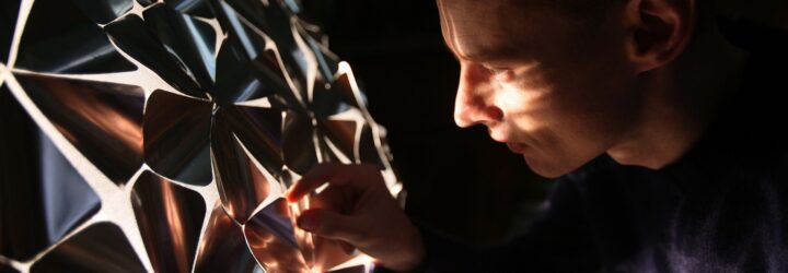 A person peering through the dome, the light from inside the dome shining on their face