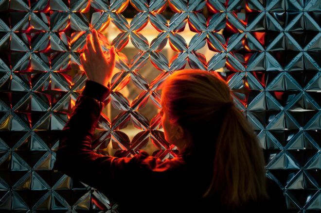 A person touching a display of diamond shaped cut outs