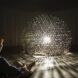 A person watching a dome structure lit with light inside of it