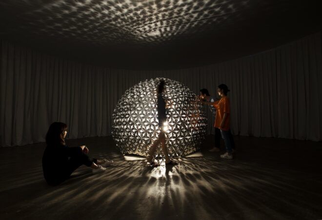 People walking by and touching the light-up dome structure