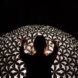 A person touching a dome structure that has multiple cutouts