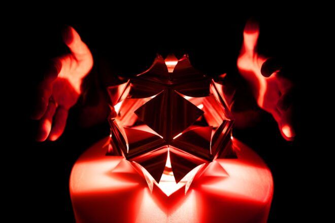 Two hands on the side of a glowing art work