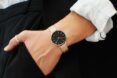 A wrist wearing a Solios Solar Watch in black and gold.