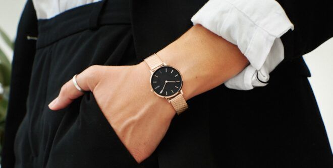 A wrist wearing a Solios Solar Watch in black and gold.