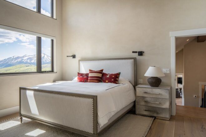 A master bedroom with large windows on the left hand side