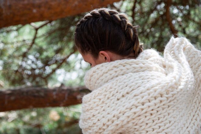 A person wrapped up in a wool scarf shot from behind