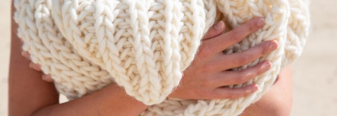 A person holding onto a wool scarf