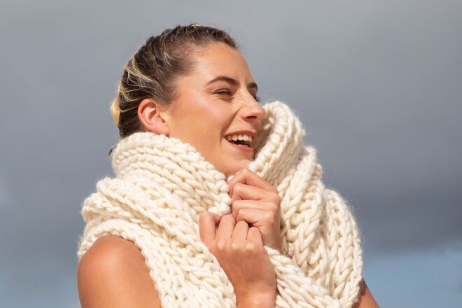 A woman wrapped in a wool scarf smiling