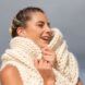 A woman wrapped in a wool scarf smiling