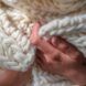 Hands touching a white wool scarf