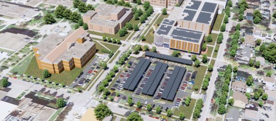 A rendering of an aerial view of a building and parking lots with solar panels on the roof.