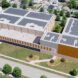 A rendering of an aerial view of a building with solar panels on the roof.