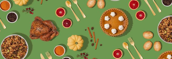 A green background with pumpkin pie, turkey, spoon and fork, cinnamon sticks and blood orange slices laid out
