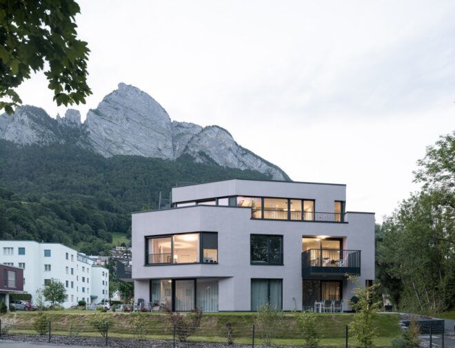 A white house sits in front of a mountain range