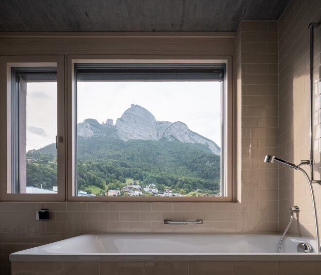 A bath tub with a window that overlooks a mountain