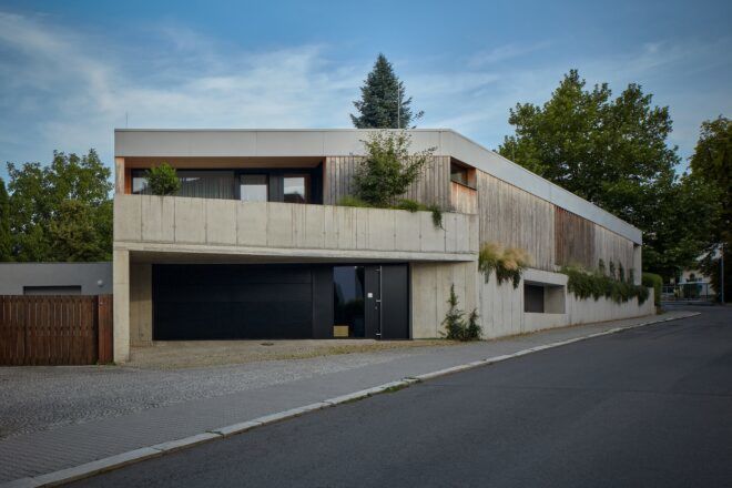 A clay-colored building with a drive way beside it