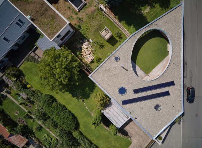 Aerial view shot downward on the land with lots of greenery and the circular cut outs in the building